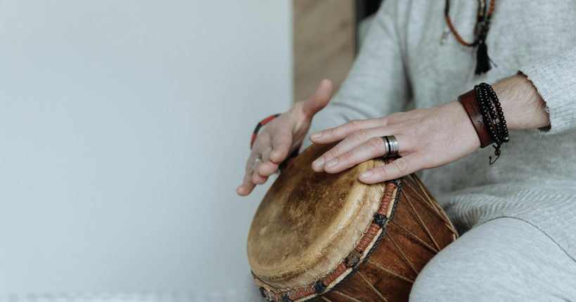 Persona tocando un instrumento de percusión.